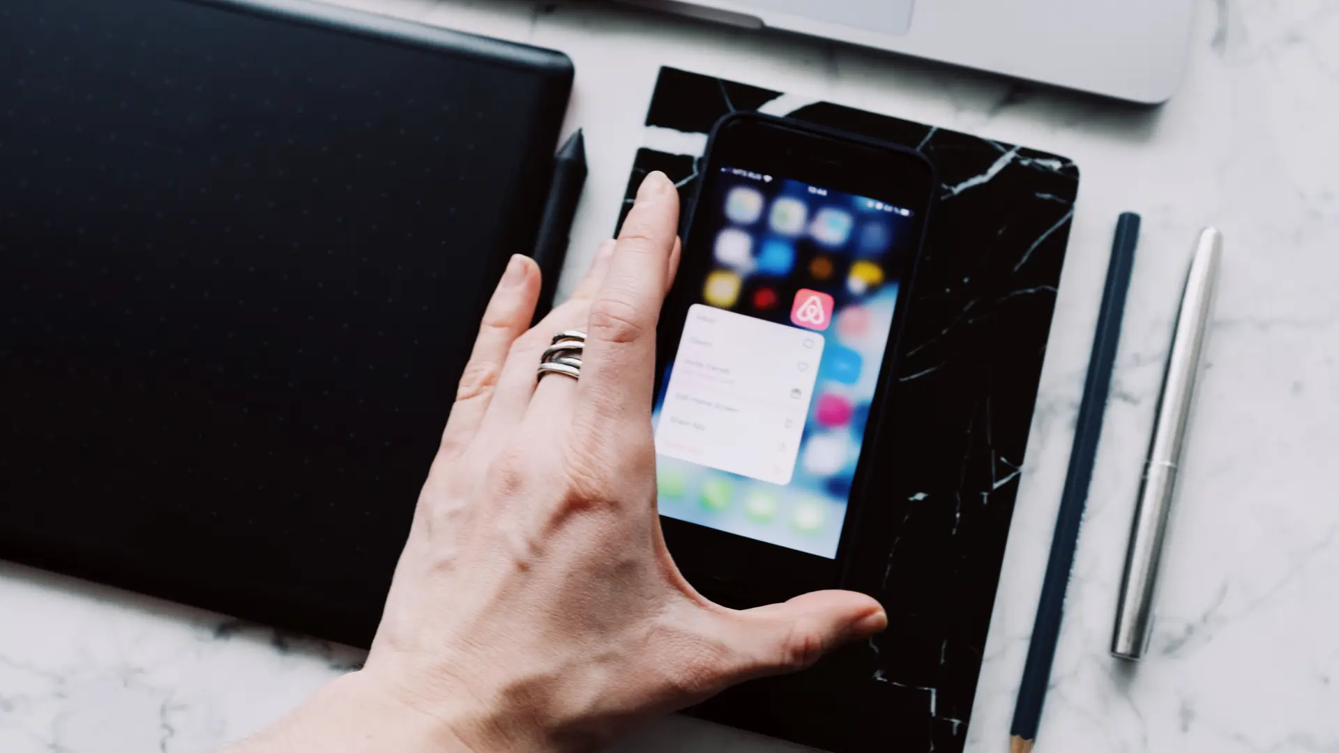 A phone app screen held above a work desk