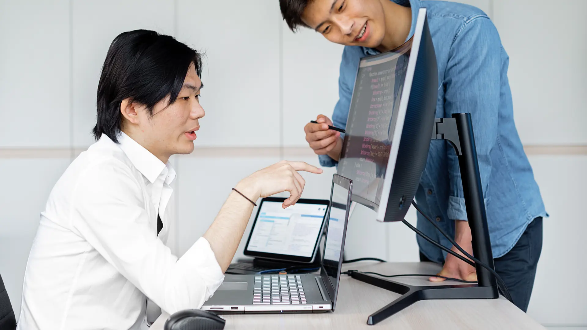 Two developers working side by side at one screen