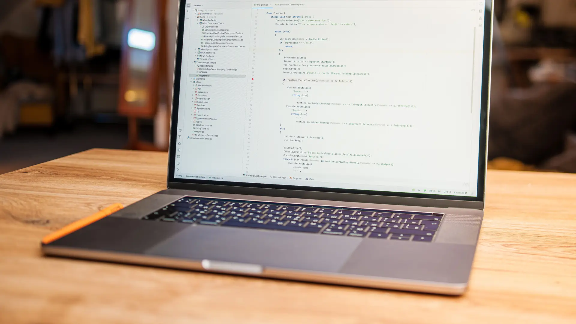 A laptop with code on screen on a bright wooden desk